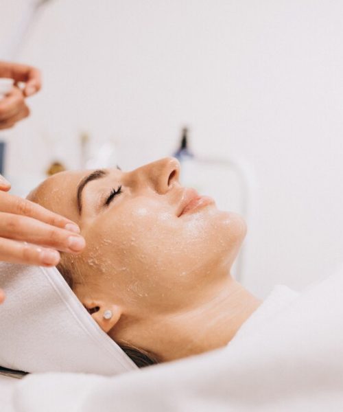 cosmetologist-cleaning-face-woman-beauty-salon_1303-16748